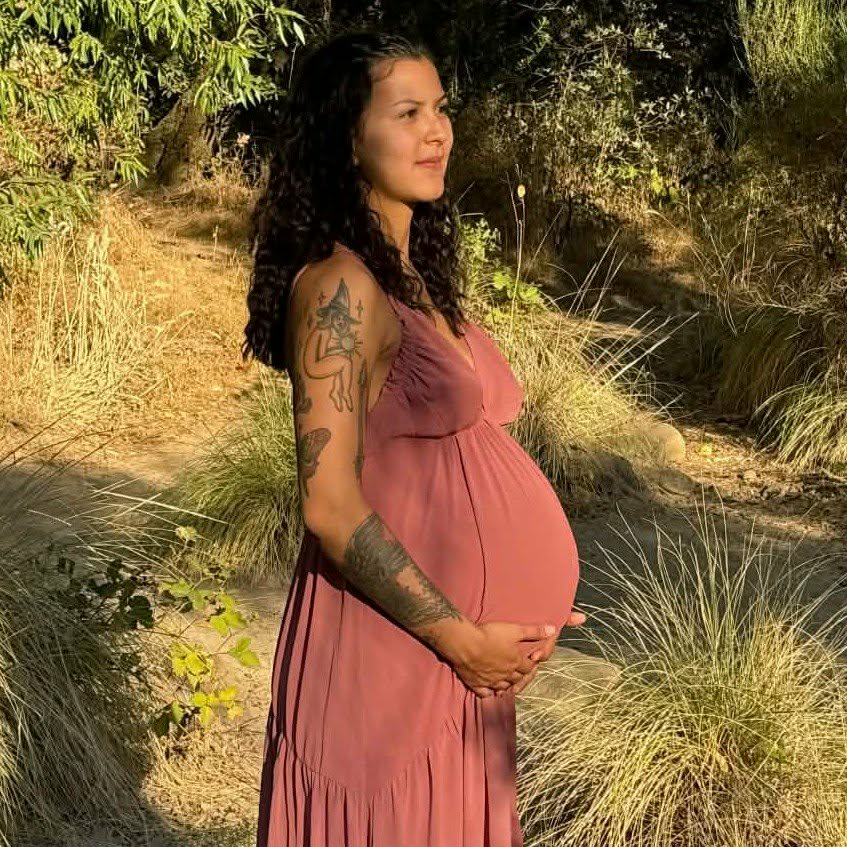 doula edith holding belly bump in the sun